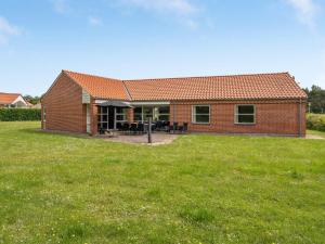 a brick house with a grass field in front of it at Holiday Home Fengur - 330m from the sea by Interhome in Humble
