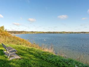 BroagerにあるHoliday Home Nica - 100m from the sea by Interhomeの湖畔の芝生の上に座るベンチ