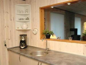 a kitchen counter with a sink and a mirror at Holiday Home Jarmunrek - 1km from the sea by Interhome in Hejls