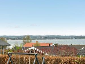 a group of houses with a lake in the background at Holiday Home Henrijette - 200m from the sea by Interhome in Sjølund +36 photos