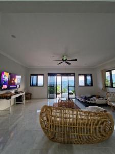 a living room with chairs and a ceiling fan at Villa Rumah Omma in Batutulis