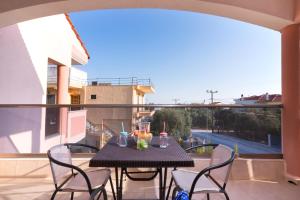 a patio with a table and chairs on a balcony at Apartments Kidonis in Limenaria
