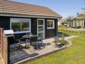 a house with a deck with a table and chairs at Holiday Home Anisa - 400m from the sea by Interhome in Haderslev