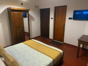 a bedroom with a bed and a flat screen tv at King's Palace in Kandy