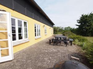 une table de pique-nique à l'extérieur d'un bâtiment jaune dans l'établissement Holiday Home Joran - 120m from the sea by Interhome, à Tranekær