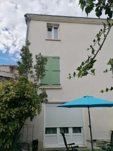 a building with a green window and an umbrella at Coquet appartement à 15mn de Paris et 10 mn de Stade de France, wifi, Netflix, in Groslay