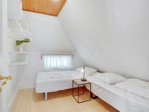 a white room with two beds and a table at Holiday Home Sirkku - 320m from the sea by Interhome in Tranekær