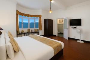 大吉岭Central Gleneagles Heritage Resort Former Bungalow of Ex-TATA Chairman Russi Mody The Mall Road Darjeeling的一间卧室，配有一张大床和一扇大窗户。