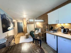 a kitchen with a table and a room with a loft at Nouveau Refuge de l aiguille in Chamonix-Mont-Blanc
