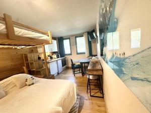 a bedroom with a bed and a kitchen with a table at Nouveau Refuge de l aiguille in Chamonix-Mont-Blanc