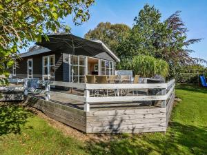 a small house with an umbrella on a yard at Holiday Home Leandra - 600m from the sea by Interhome in Augustenborg +26 photos