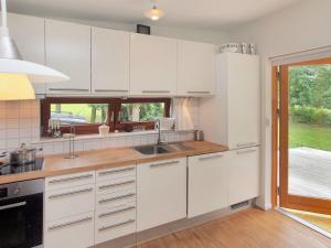 a kitchen with white cabinets and a sink at Holiday Home Pirjo - 50m from the sea by Interhome in Haderslev