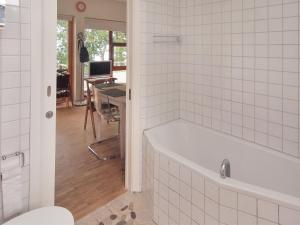 a white tub in a bathroom with a desk at Holiday Home Pirjo - 50m from the sea by Interhome in Haderslev