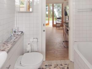 a white bathroom with a toilet and a tub at Holiday Home Pirjo - 50m from the sea by Interhome in Haderslev +11 photos