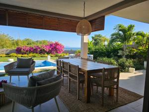 a patio with a table and chairs and a pool at Villa Solenzara - Private Luxury Residence Nosy Be in Nosy Be