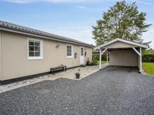 a house with a garage with a bench in the driveway at Holiday Home Haralda - 300m from the sea by Interhome in Haderslev