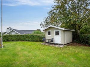 a small shed with two chairs in a yard at Holiday Home Haralda - 300m from the sea by Interhome in Haderslev +29 photos