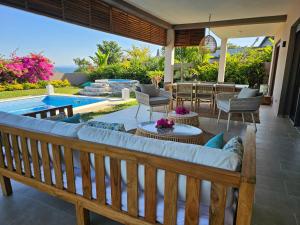 a patio with a bench and a swimming pool at Villa Solenzara - Private Luxury Residence Nosy Be in Nosy Be