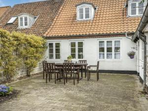 a table and chairs in front of a white house at Holiday Home Ajna - 9-8km from the sea by Interhome in Tønder