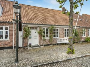 a brick house with a bench in front of it at Holiday Home Ajna - 9-8km from the sea by Interhome in Tønder