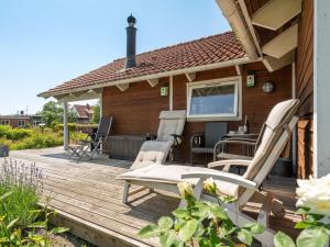 a wooden deck with chairs and a table on it at Holiday Home Kaike - 100m from the sea by Interhome in Haderslev