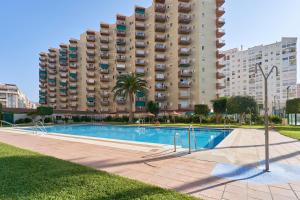 a swimming pool in front of a large building at Apartamento Gondolas Costa Tropical in Almuñécar