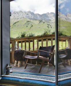 a porch with two chairs and a view of mountains at Les Rhodos in La Clusaz