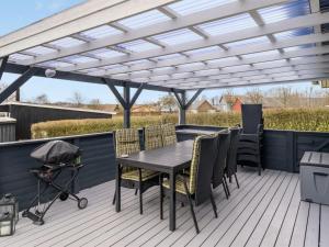 a white pergola on a deck with a table and chairs at Holiday Home Aloisia - 300m from the sea by Interhome in Broager