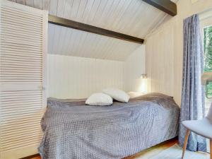a bedroom with a bed with two pillows on it at Holiday Home Rentje - 31km from the sea by Interhome in Toftlund