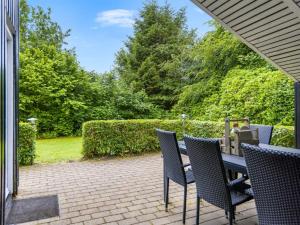 a patio with chairs and a table with a phone on it at Holiday Home Corinna - 28km from the sea by Interhome in Toftlund