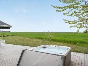 a hot tub sitting on a patio next to a field at Holiday Home Ajla by Interhome in Bredebro +29 photos