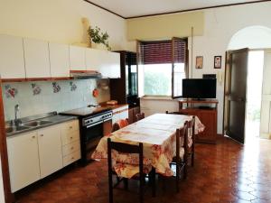 a kitchen with a table and a sink and a stove at Cavadozza by Caseaponza it in Ponza +24 photos