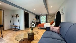 un soggiorno con un divano blu e un letto di Hotel Le Galambre a Nîmes