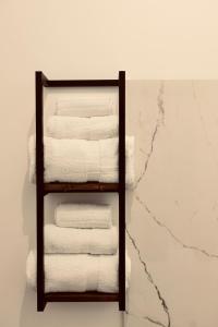 un portasciugamani pieno di asciugamani bianchi su una parete di Elene Suites Boutique a Palermo