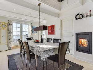 a dining room with a table and chairs and a fireplace at Apartment Joar - 5m to the inlet by Interhome in Gråsten