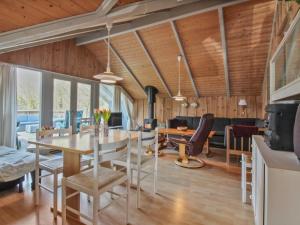 a dining room and living room with a table and chairs at Holiday Home Carlotta - 12km from the sea by Interhome in Oksbøl