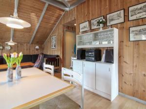 a kitchen and dining room with a table and a refrigerator at Holiday Home Carlotta - 12km from the sea by Interhome in Oksbøl +12 photos
