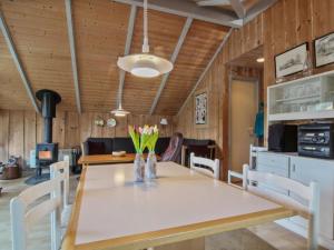 a dining room with a table and a stove at Holiday Home Carlotta - 12km from the sea by Interhome in Oksbøl