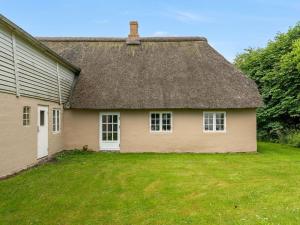 an old house with a thatched roof and a yard at Holiday Home Thorarin - 25km from the sea by Interhome in Højer