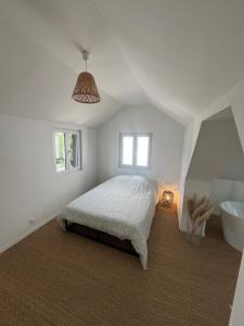 a white bedroom with a bed and a bath tub at Maison cosy & chaleureuse - Jardin & Piscine in Hoenheim