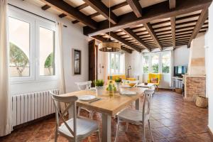 a dining room with a wooden table and chairs at Villa Gregal in Cala Blanca