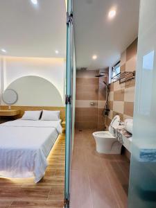 a bedroom with a bed and a bathroom with a tub at Tom's Homestay 2 in Hue