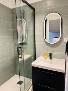 a bathroom with a sink and a glass shower at Forest - Nid au coeur de Fougères in Fougères