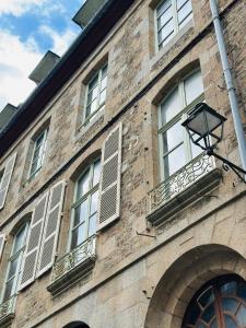 a brick building with windows and a street light at Forest - Nid au coeur de Fougères in Fougères