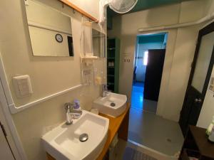 東京にあるSTAY WORK ASAKUSA guest house 浅草店の洗面台と鏡のあるバスルーム