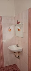 a bathroom with a sink and a mirror on the wall at Mattuppavu Beach House in Vilinjam