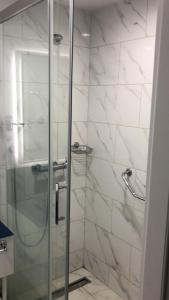 a bathroom with a shower with a glass door at Studio Suite with balcony in Batumi