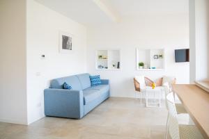 a living room with a blue couch and a table at Capri Koral Guest House in Capri