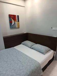 a bedroom with two beds and a painting on the wall at Lumut Valley in Lumut +23 photos