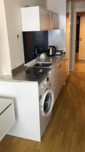 a kitchen with a sink and a washing machine at Studio Suite with balcony in Batumi